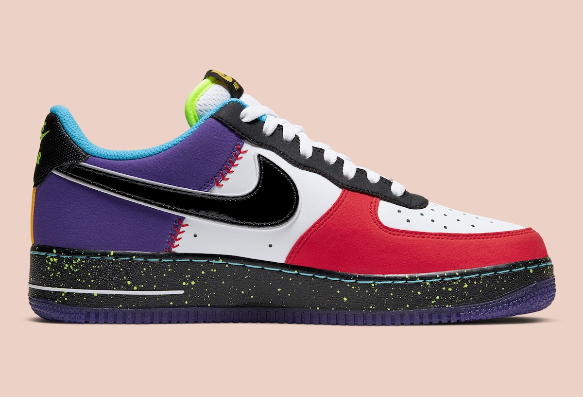 Lado interno de la zapatilla izquierda del Nike Air Force 1 Low What The LA sobre fondo rosa claro, con puntera blanca y roja, un swoosh negro de charol, panel violeta con costuras rojas estilo pelota de béisbol, cuello celeste y mediasuela negra con salpicado verde flúor sobre suela violeta