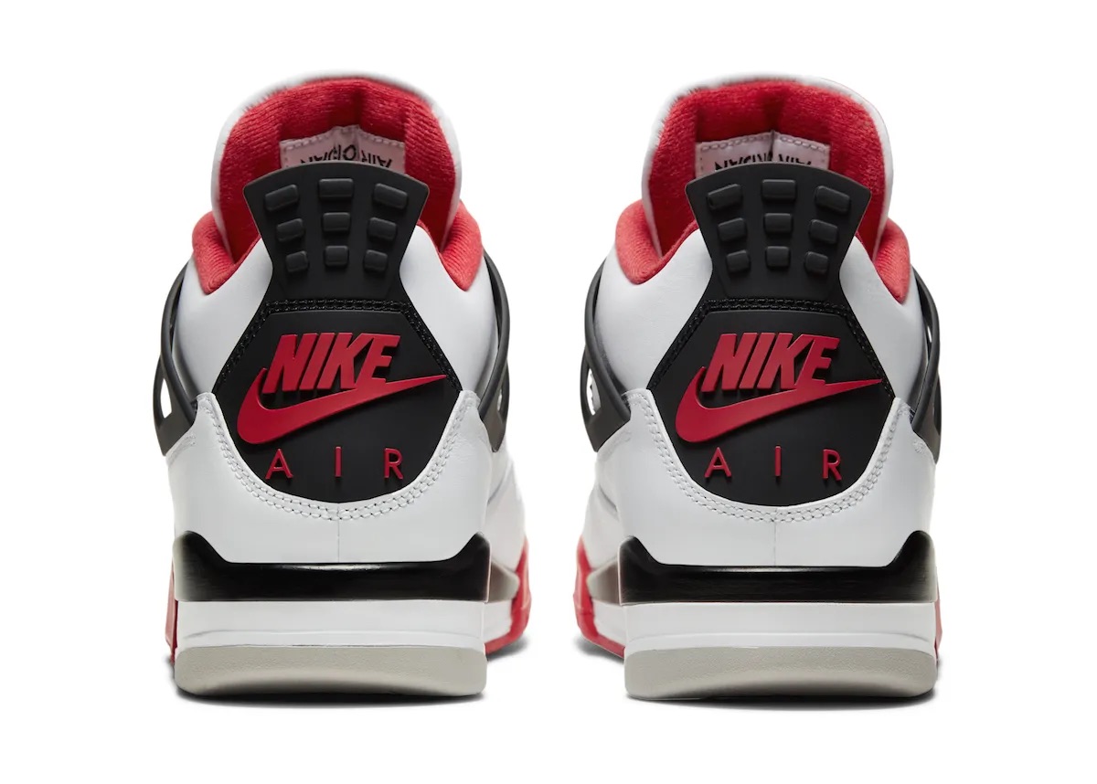 Foto de archivo: vista trasera del par de Air Jordan 4 Fire Red de 2020 sobre fondo blanco, con la pieza del talón negra, el logo Nike con swoosh y la palabra AIR en rojo, el forro rojo, la mediasuela negra y blanca y la suela gris