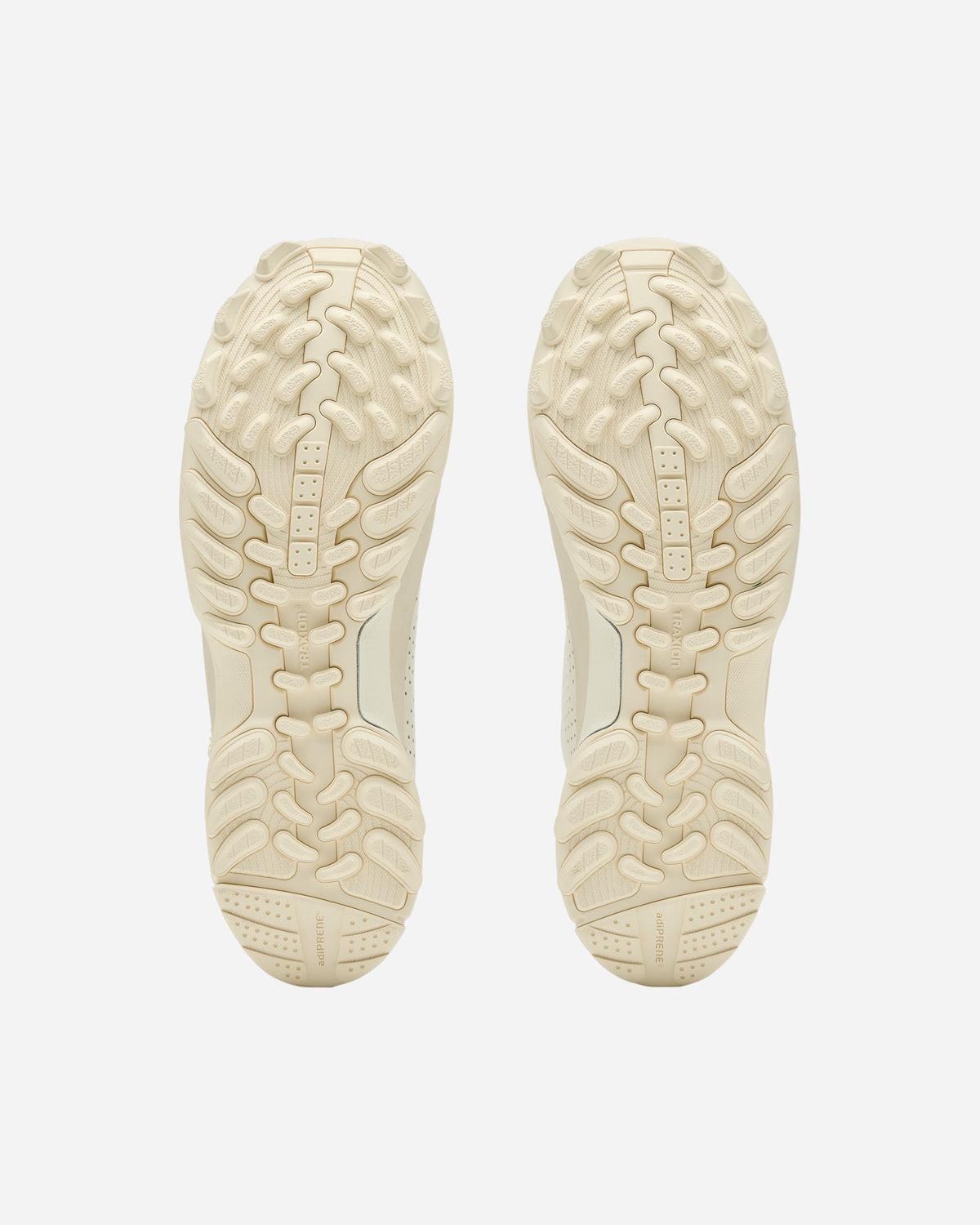 Suelas de la Arte Antwerp x adidas GSG9 Off White vistas desde abajo, en el mismo tono crudo que el upper, con tacos de agarre en toda la superficie y las inscripciones TRAXION en el centro y adiPRENE en el talón
