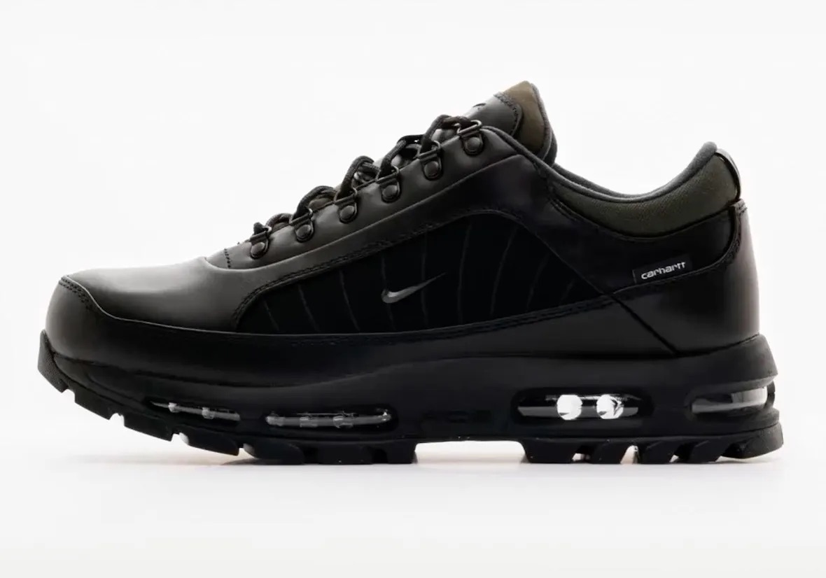 Nike Air Max Goadome Low de Carhartt WIP en negro de perfil sobre fondo blanco, con cuero negro, panel lateral negro con costuras, Swoosh metálico chico, argollas de metal y la cámara Air visible en la suela