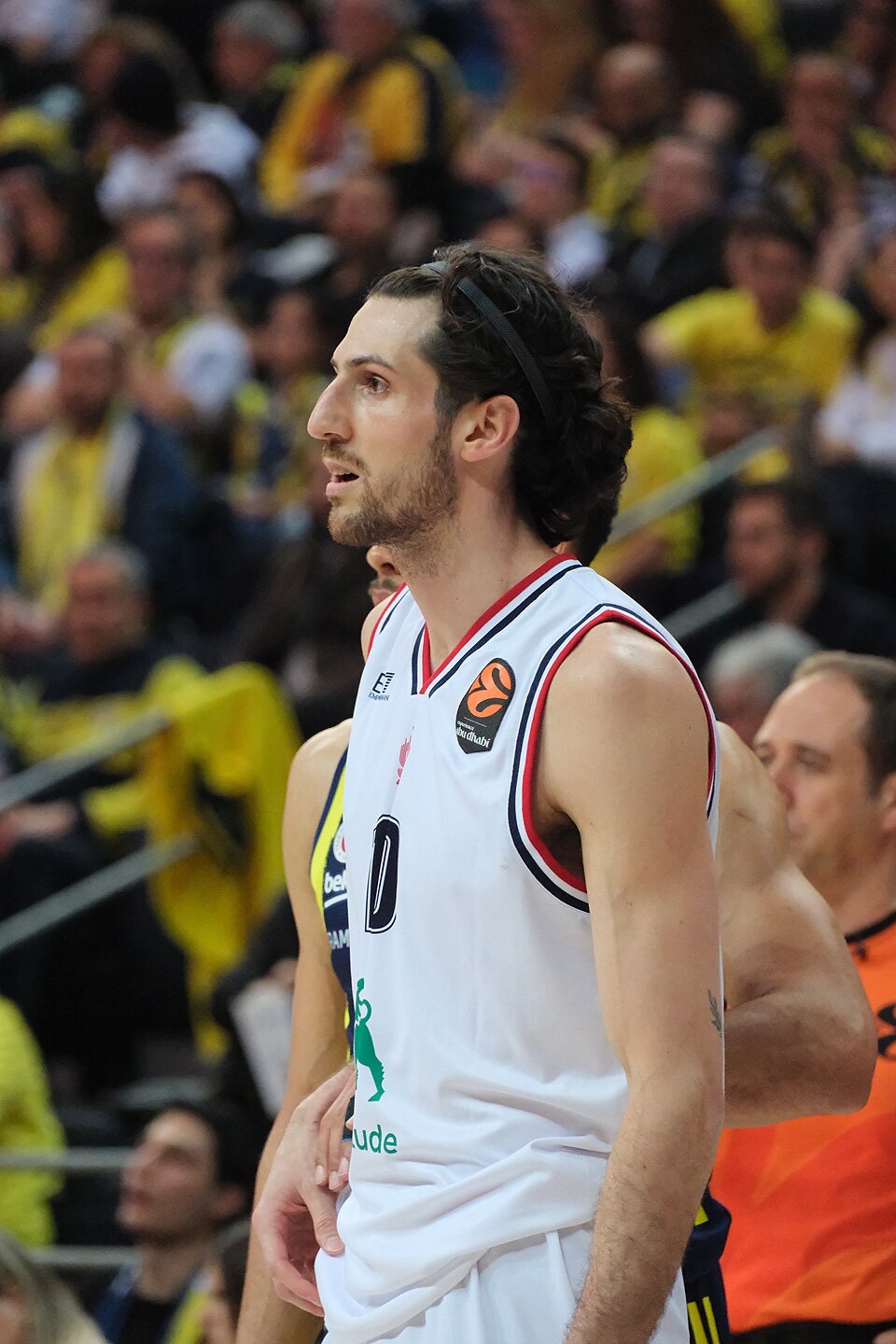 Foto de archivo: Leandro Bolmaro, de perfil con la camiseta blanca del Olimpia Milano y una vincha negra, durante un partido de Euroliga con el público de amarillo detrás