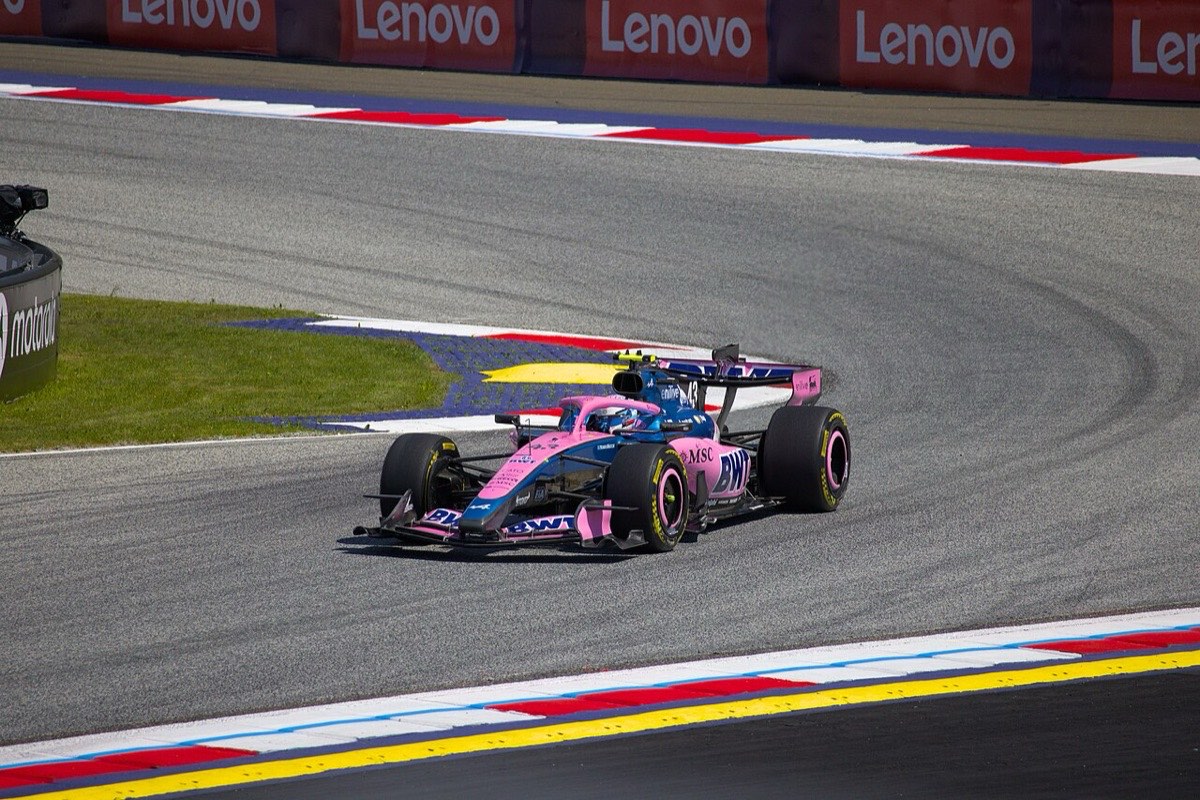 Foto de archivo: el Alpine azul y rosa número 43 de Franco Colapinto sale de una curva del Red Bull Ring, con los pianos rojos y blancos y la tribuna de fondo