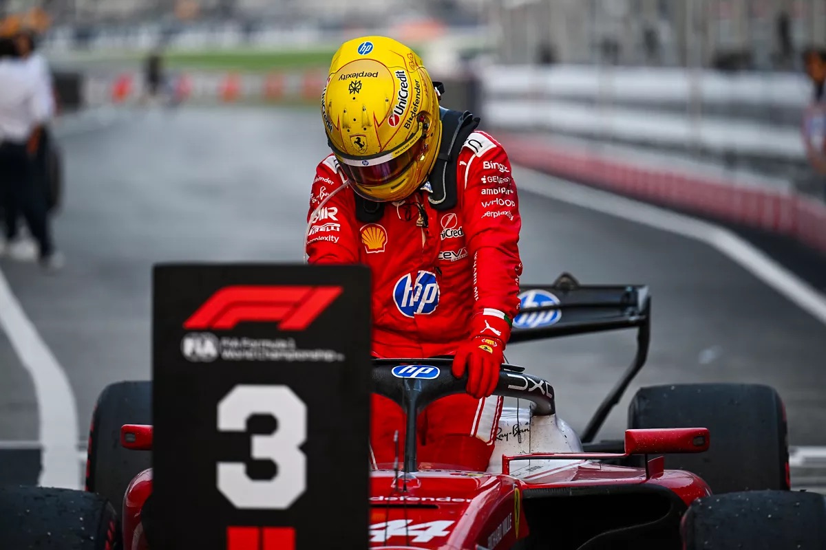 Lewis Hamilton se baja del Ferrari número 44 junto al cartel del tercer puesto