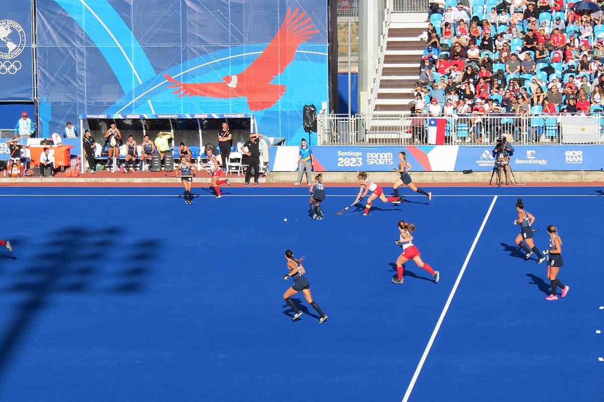 Foto de archivo: jugadoras de Argentina, de azul oscuro, y de Canadá, de rojo y blanco, corren detrás de la bocha en una cancha azul con tribunas llenas