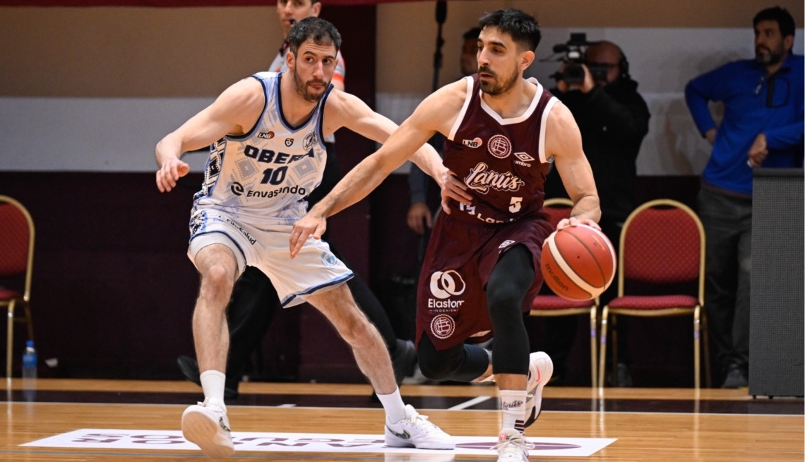 Un jugador de Lanús con la camiseta granate 5 avanza con la pelota ante la marca de un jugador de Oberá con la camiseta blanca 10, en el Antonio Rotili