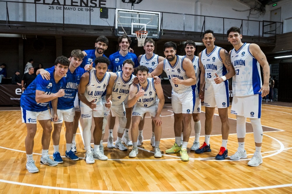 El plantel de La Unión de Formosa posa en el centro de la cancha de Platense después del partido, con camisetas blancas y azules