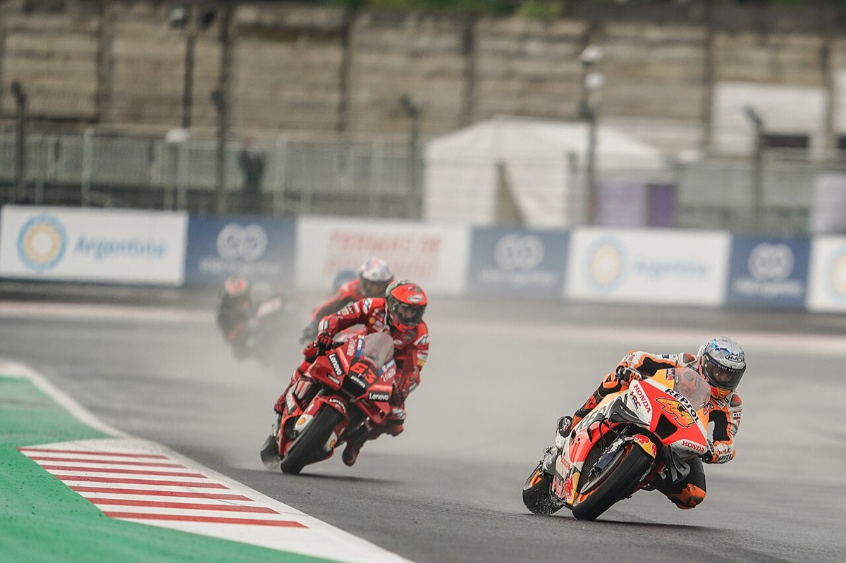 Foto de archivo: Pol Espargaró, con la Honda naranja y roja, encabeza un grupo de motos bajo la lluvia en Mandalika, seguido por la Ducati roja de Francesco Bagnaia