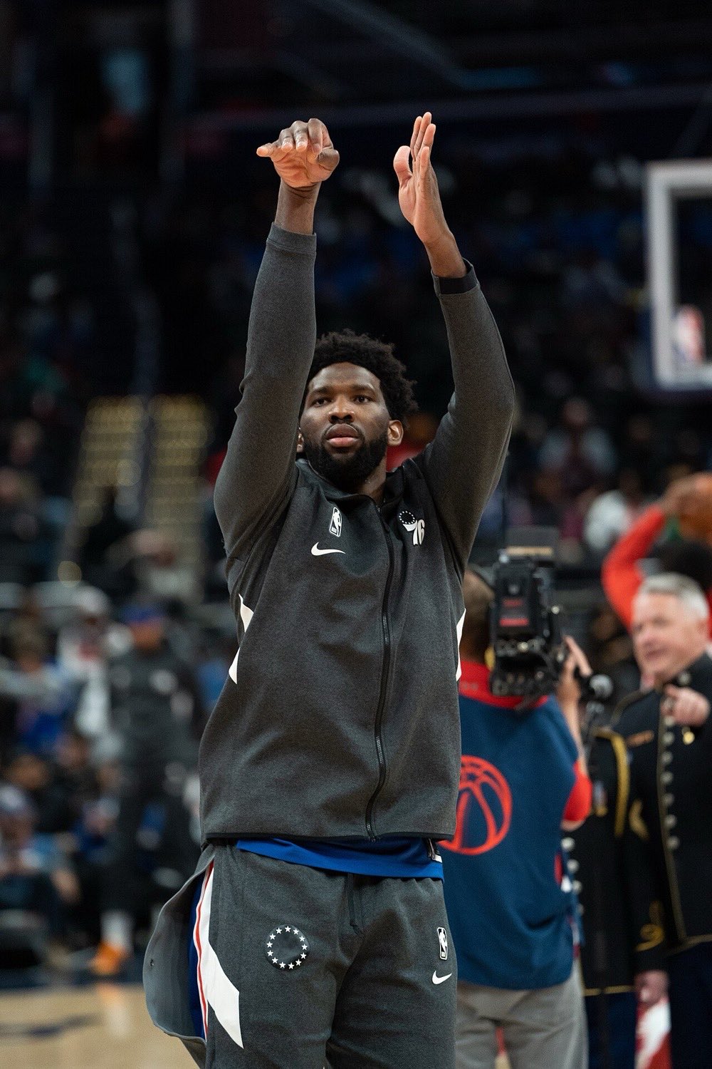 Foto de archivo: Joel Embiid, con campera gris de los 76ers, lanza en la entrada en calor antes de un partido, con el público de fondo