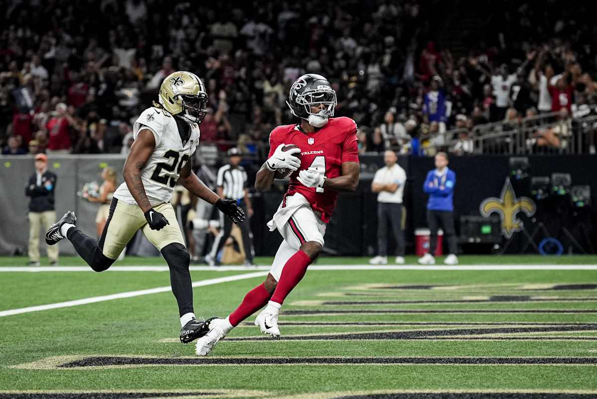 Jahan Dotson, con la camiseta roja número 4 de los Falcons, atrapa la pelota en la zona de anotación delante de un defensor de los Saints