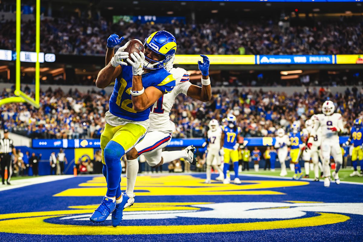 Puka Nacua, con la camiseta azul número 12 de los Rams, atrapa la pelota en la zona de anotación delante de un defensor de los Bills en el SoFi Stadium