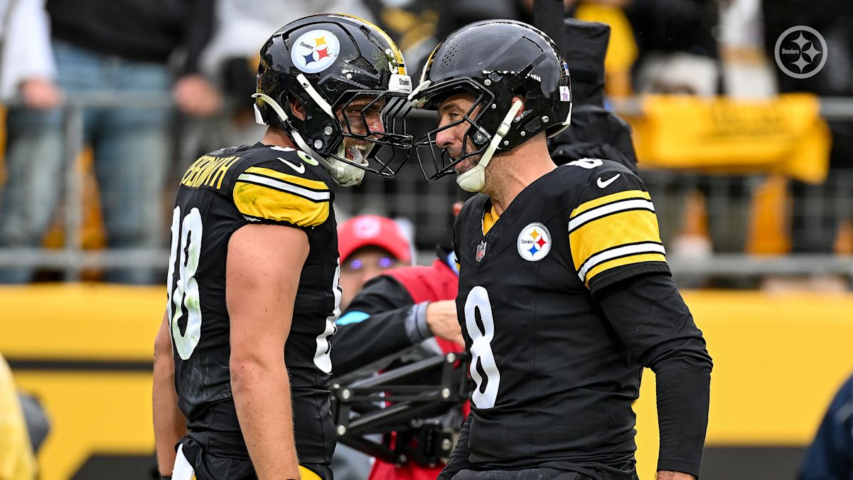 Pat Freiermuth, con el número 88, y Aaron Rodgers, con el 8, se miran cara a cara para festejar un touchdown de los Steelers en el Acrisure Stadium