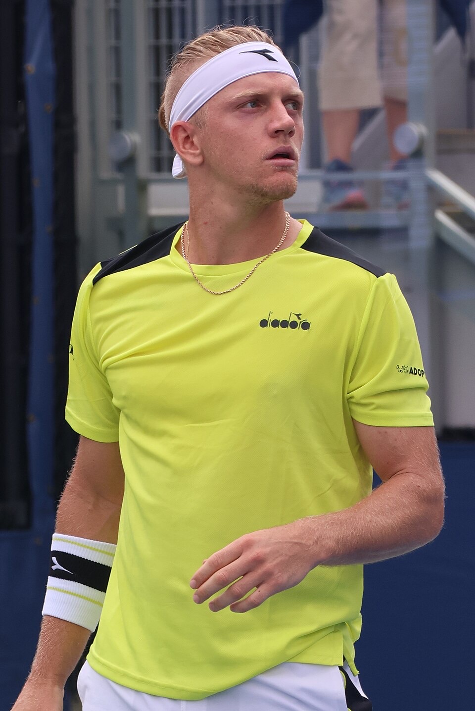 Foto de archivo: Alejandro Davidovich Fokina, con vincha blanca y remera amarilla flúor, mira hacia un costado en la cancha del US Open 2023