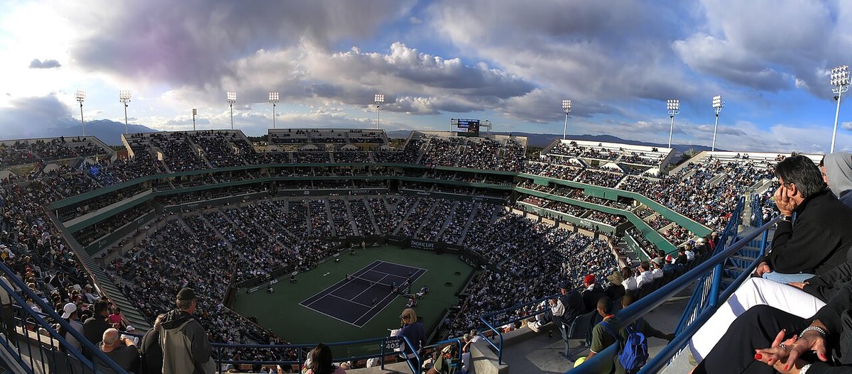 Foto de archivo: vista panorámica del estadio principal de Indian Wells, con las tribunas llenas y la cancha azul en el centro bajo un cielo con nubes