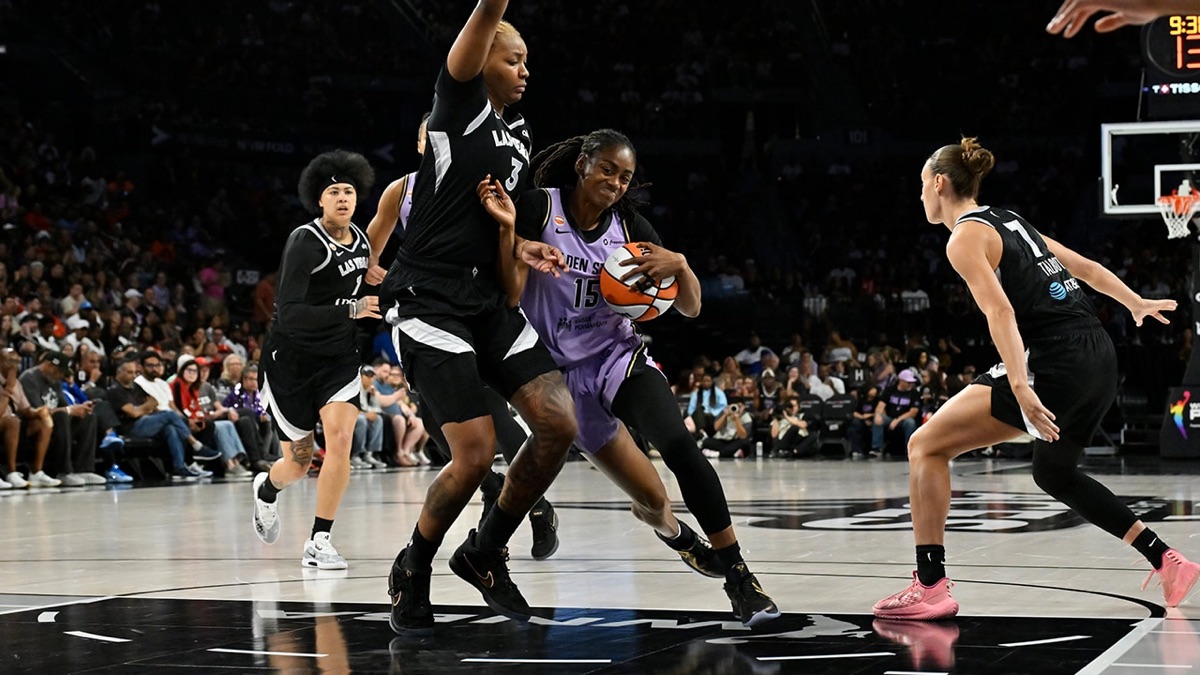 Una jugadora de Golden State Valkyries con la camiseta 15 avanza con la pelota entre jugadoras de Las Vegas Aces vestidas de negro
