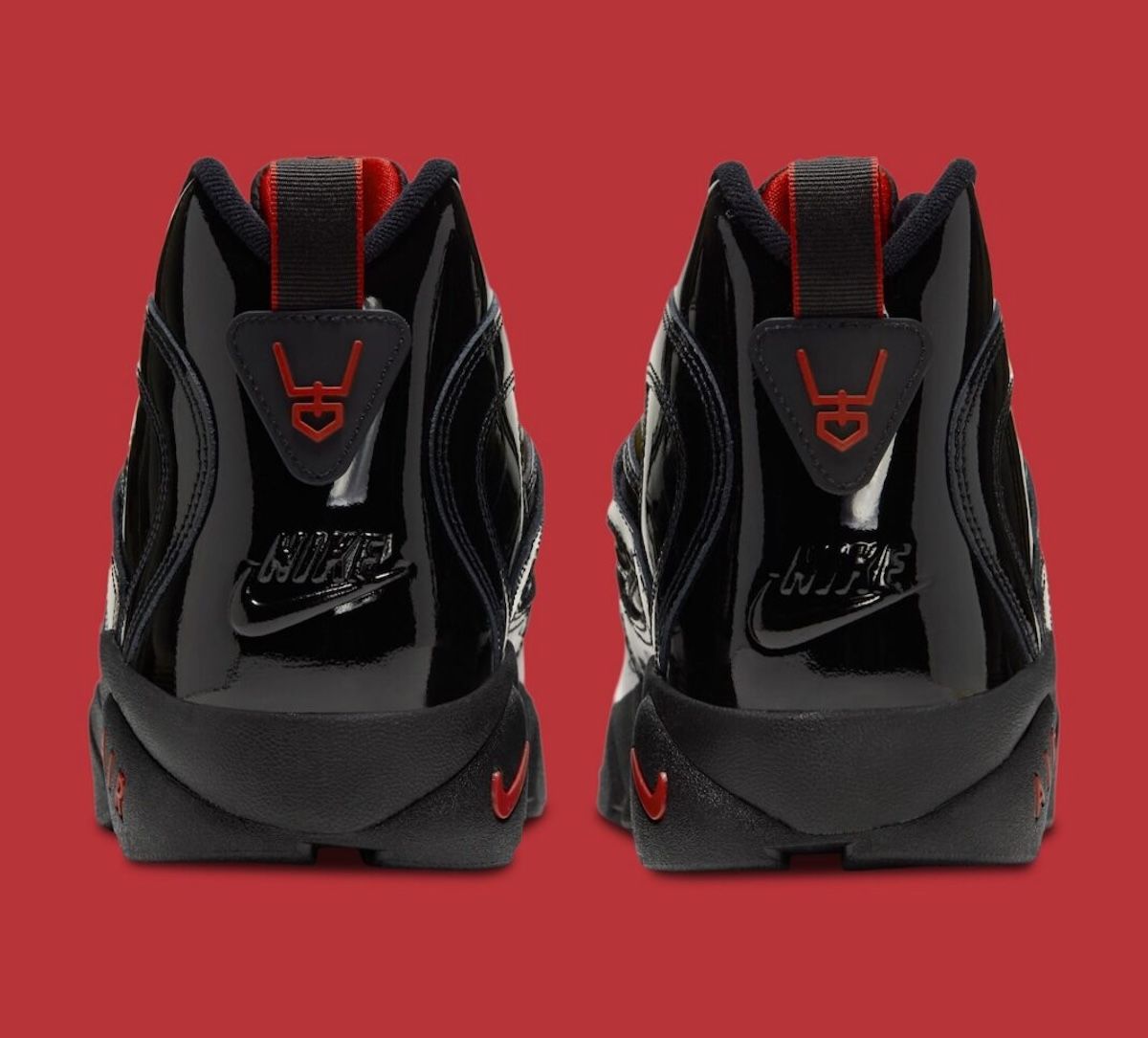 Talones de la Nike Air Diamond Turf 2 en charol negro, con el logo de Deion Sanders en rojo y la palabra Nike en relieve