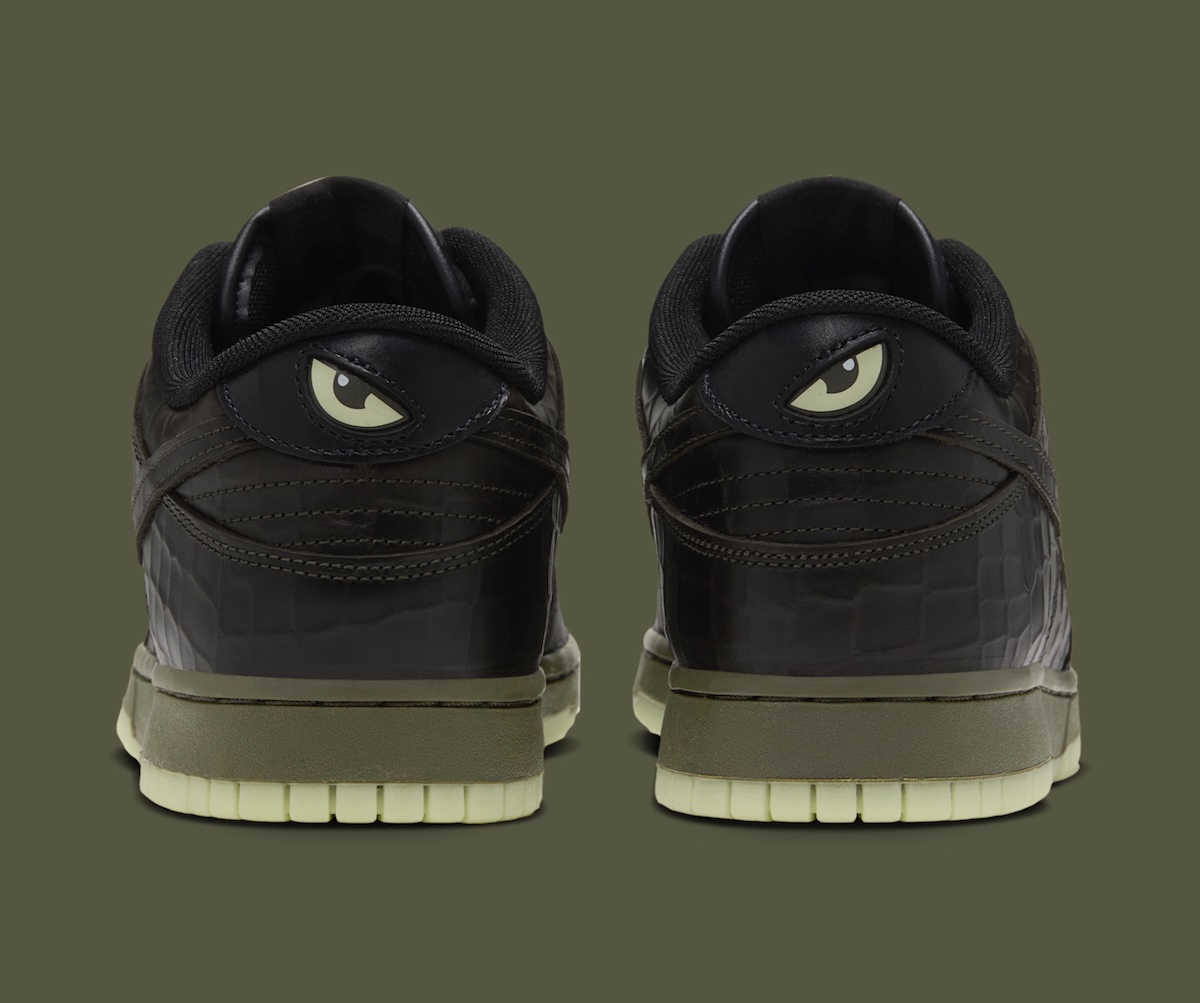 Talón del Nike Dunk Low Shibuya Halloween visto desde atrás, con un ojo verde claro en cada talón, cuero negro texturado, mediasuela verde oliva y suela verde clara