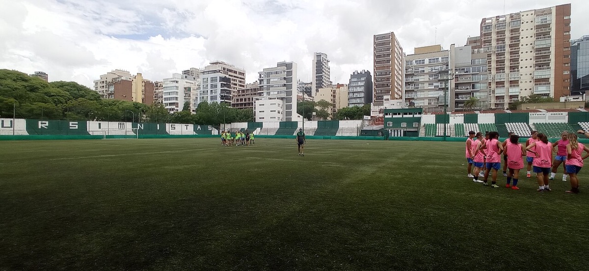 El estadio de Excursionistas, en el Bajo Belgrano, con su tribuna baja verde y blanca y los edificios del barrio de fondo; foto de archivo de febrero de 2023 (foto: BugWarp, Wikimedia Commons, dominio público, CC0)