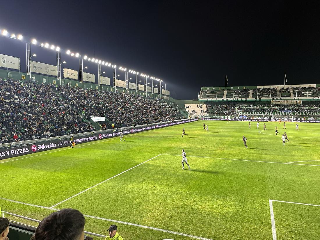 Vista nocturna del estadio Florencio Sola, en Banfield, con las tribunas llenas de hinchas locales durante un partido ante Platense (foto de archivo de abril de 2023: Vincenzo Togni, Wikimedia Commons, licencia CC BY 4.0)