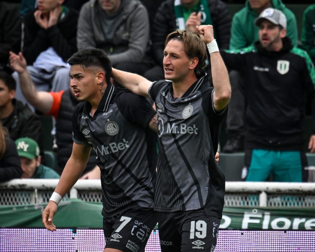 Dos jugadores de Argentinos Juniors, con la camiseta negra y gris, festejan abrazados durante el partido ante Banfield en el Florencio Sola (foto: Liga Profesional de Fútbol)