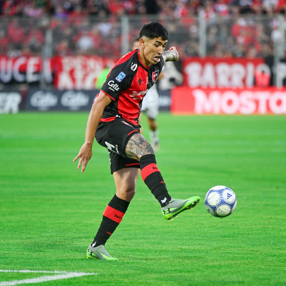 Un jugador de Newell's, con la camiseta rojinegra, prepara un pase con la zurda en el estadio Marcelo Bielsa, con la tribuna local de fondo, durante la fecha 13 del Clausura (foto: Liga Profesional de Fútbol)