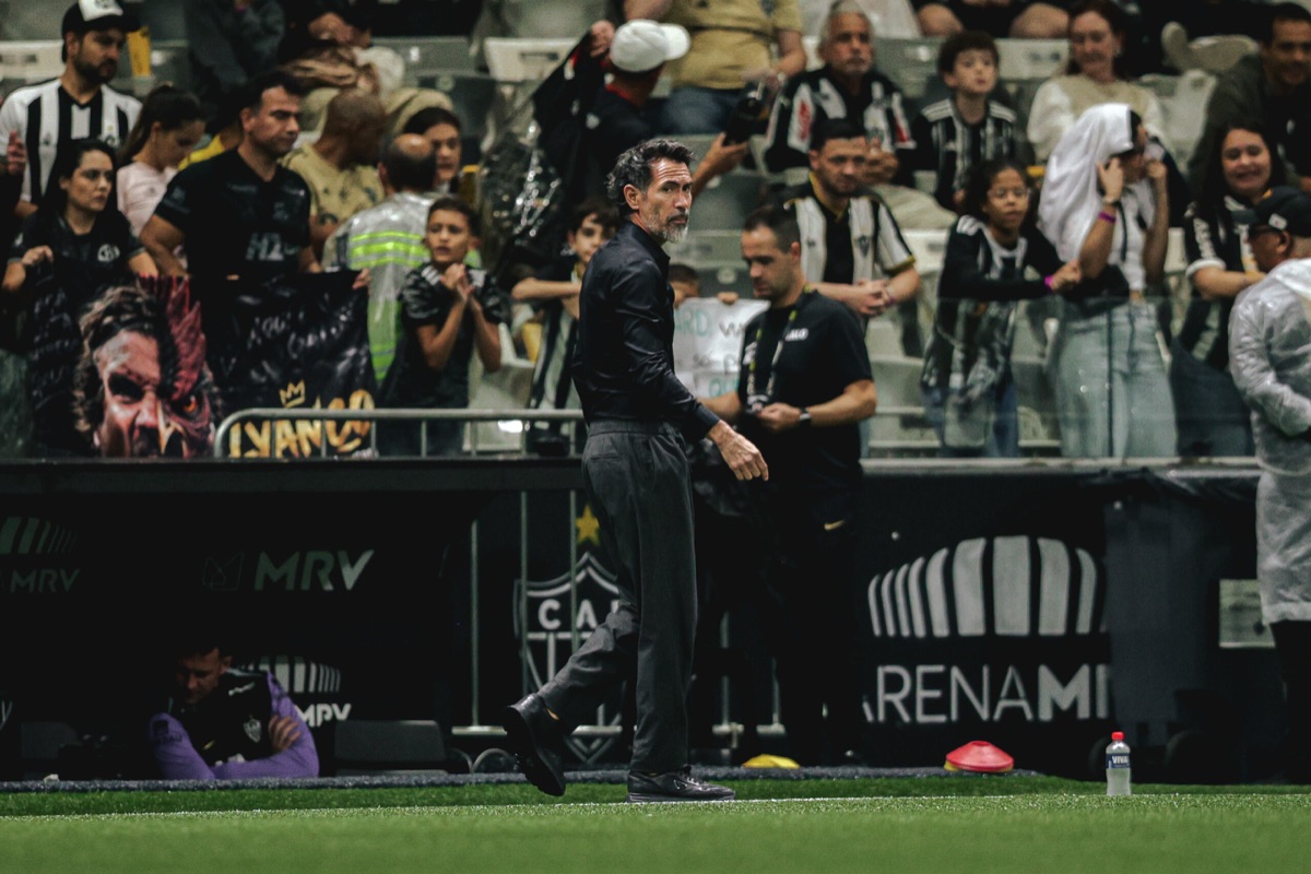 Eduardo Domínguez, técnico de Atlético Mineiro, vestido de negro, camina junto al costado de la cancha de la Arena MRV con la hinchada de fondo (foto: prensa oficial de Atlético Mineiro)