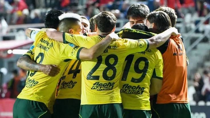 Los jugadores de Defensa y Justicia, con la camiseta amarilla y verde, se abrazan para festejar uno de los goles ante Unión en Santa Fe (foto: prensa Defensa y Justicia)