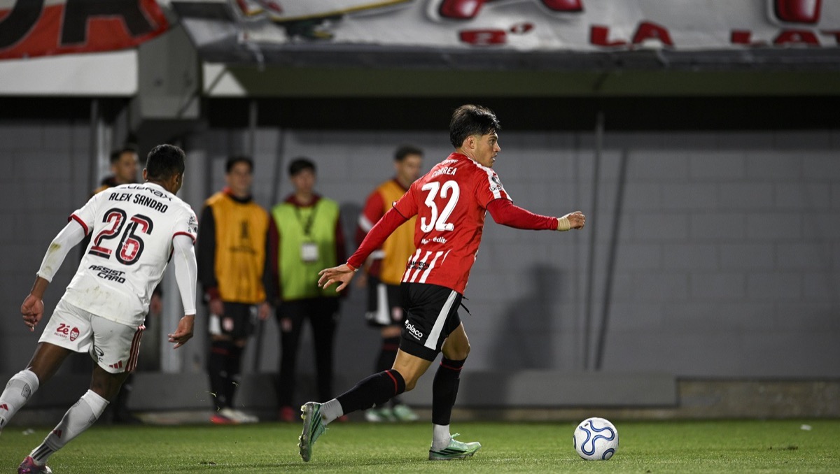 Un jugador de Estudiantes, con la camiseta roja y blanca y el número 32, conduce la pelota ante Alex Sandro, de Flamengo, con camiseta blanca, en el estadio UNO durante la ida de la semifinal; foto de archivo del jueves 15 de octubre (foto: prensa Estudiantes de La Plata)