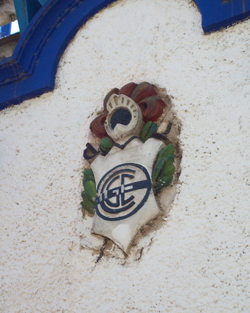 El escudo de Gimnasia y Esgrima La Plata en relieve sobre una pared del estadio Juan Carmelo Zerillo; foto de archivo de 2011 (foto: Sergio Panei Pitrau, Wikimedia Commons, licencia CC BY 3.0)