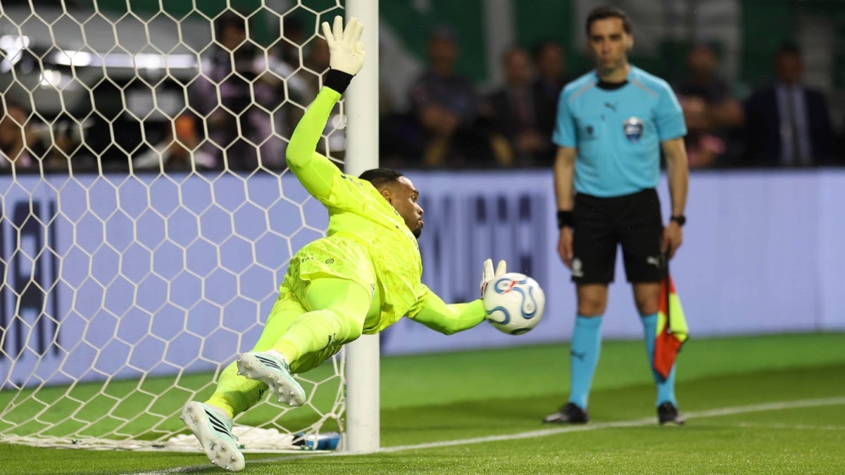 Carlos Miguel, arquero de Palmeiras, vestido de verde flúor, se estira contra el palo y ataja un penal en la definición con Fluminense en el Nubank Parque (foto: Cesar Greco / Palmeiras)
