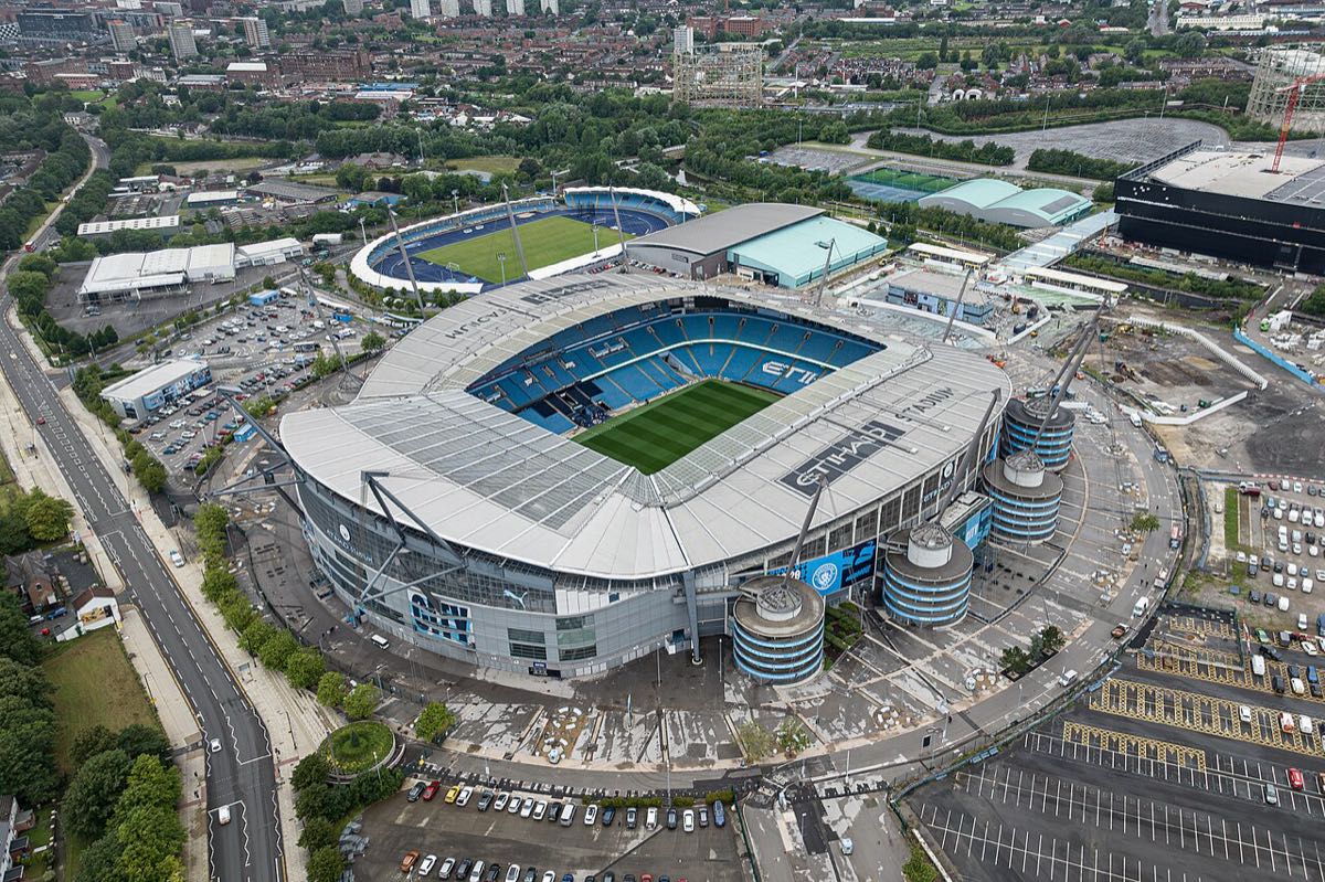 Vista aérea del Etihad Stadium, la cancha de Manchester City, con el estacionamiento y el barrio alrededor; foto de archivo de julio de 2023 (foto: Arne Müseler, recortada por Blackcat, Wikimedia Commons, licencia CC BY-SA 3.0 DE)