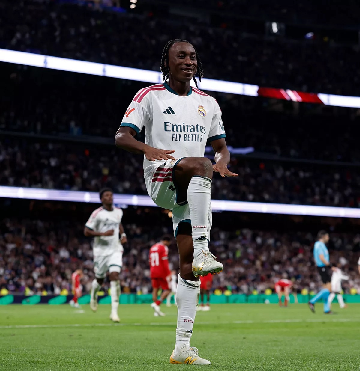 Yan Diomande, con la camiseta blanca del Real Madrid y el número 25, festeja su gol levantando una rodilla en el Bernabéu, con jugadores del Sevilla de rojo detrás (foto: Real Madrid C.F.)