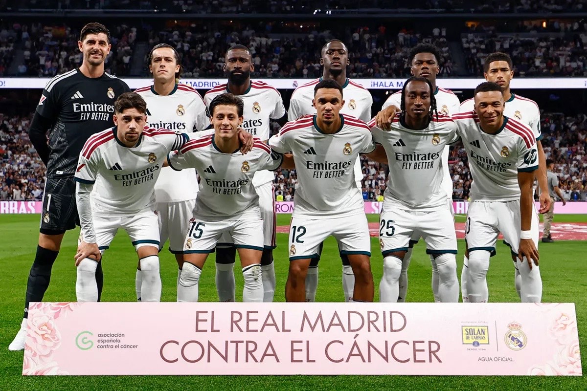 El once inicial del Real Madrid posa en el Bernabéu antes del partido con el Villarreal, detrás de una pancarta contra el cáncer (foto: Real Madrid C.F.)
