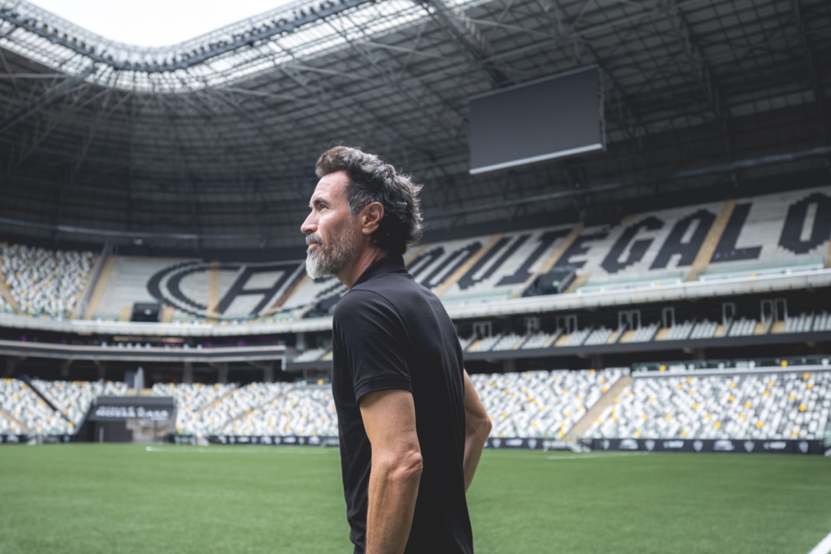 Eduardo Domínguez, entrenador de Atlético Mineiro, con remera negra, mira la cancha vacía de la Arena MRV; foto de archivo (foto: Pedro Souza / prensa oficial de Atlético Mineiro)