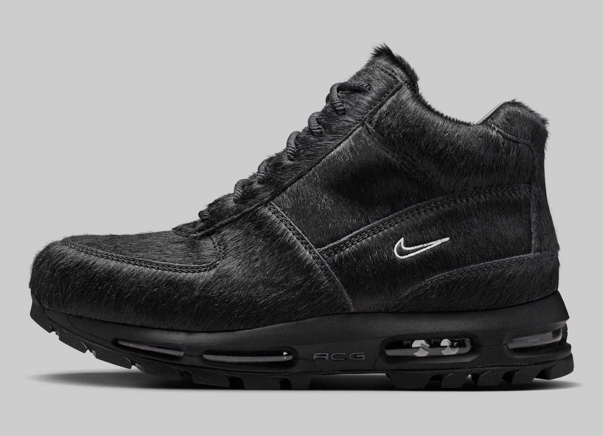 Nike Air Max Goadome Black Pony Hair de perfil sobre fondo gris, toda negra con pelo de potro, Swoosh blanco bordado y suela negra con cámara de aire