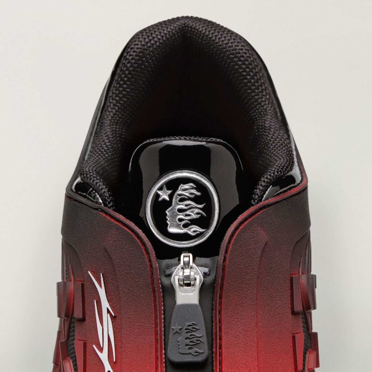 HELLSTAR x adidas Megaride S2 Red/Black visto desde arriba, con el cierre frontal y su tirador con logo de HELLSTAR, el medallón plateado de la marca en la lengüeta y el degradé de negro a rojo en el empeine
