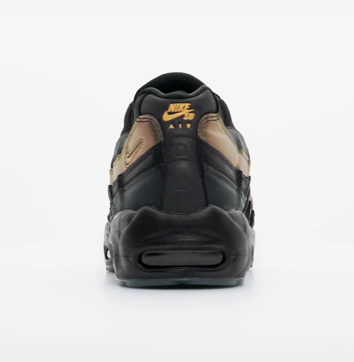 Talón del Kyle Wilson x Nike SB Air Max 95 sobre fondo gris claro, con el logo Nike SB Air en dorado, la franja verde y dorada del costado y la unidad Air oscura