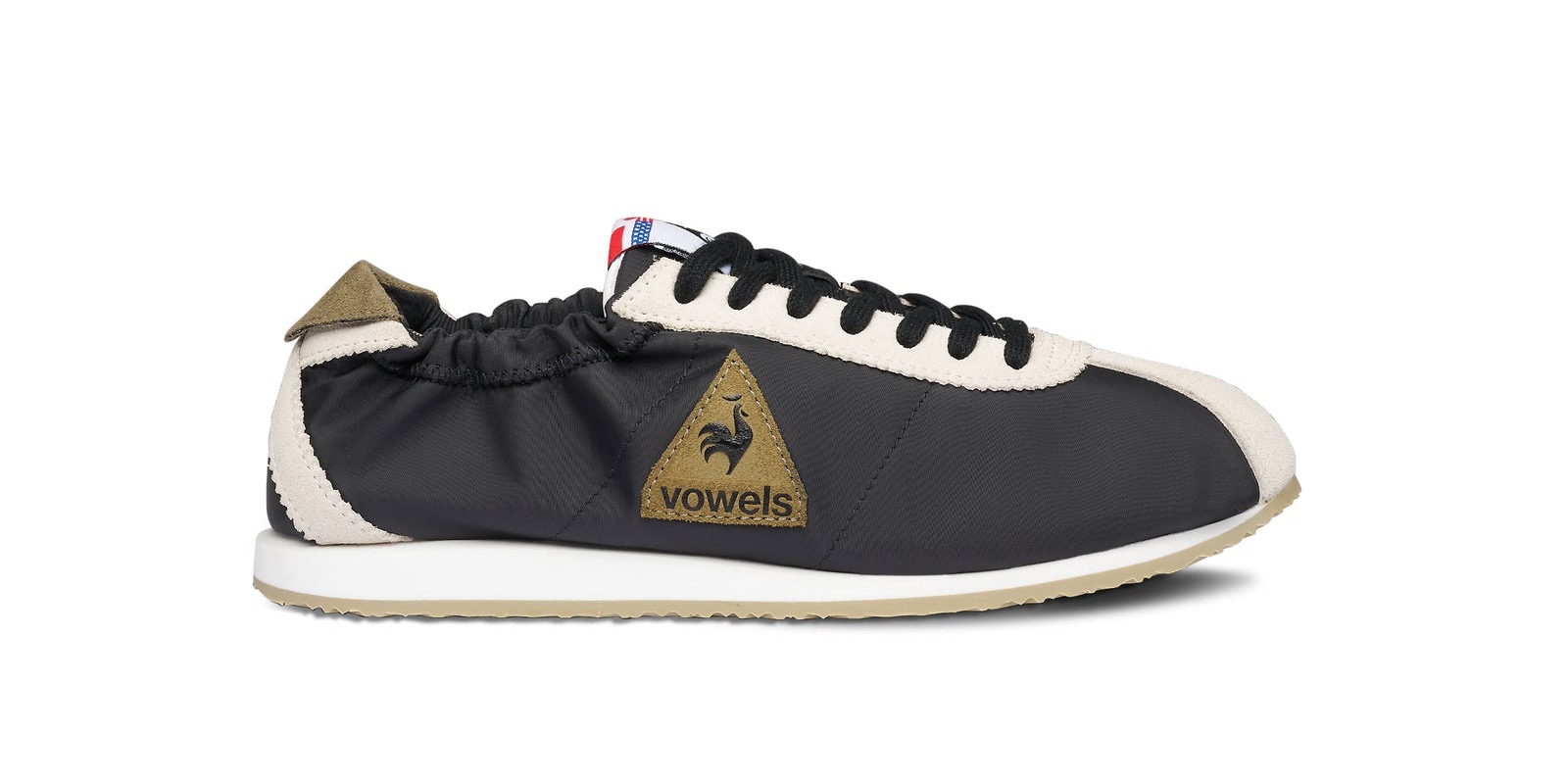 Vista lateral de la vowels x Le Coq Sportif Wendon negra con parche triangular de gamuza oliva y talón elastizado