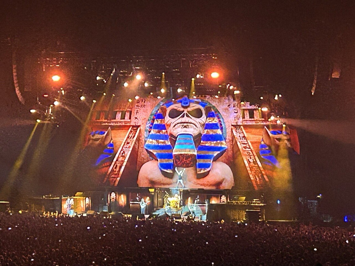 Escenario de la Run For Your Lives World Tour de Iron Maiden en París, el 20 de julio de 2025 (foto de archivo): una pantalla gigante muestra a Eddie como faraón, con tocado azul y dorado, entre columnas egipcias y luces naranjas, sobre la banda tocando frente a una multitud. Foto: Chris93, Wikimedia Commons, CC BY-SA 4.0
