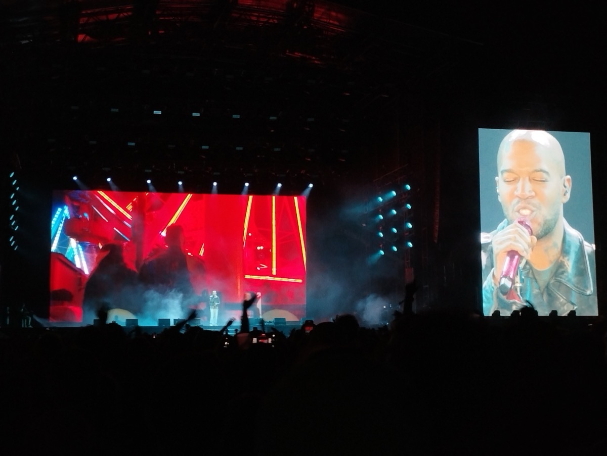 Kid Cudi en vivo en Rock en Seine, en agosto de 2025: el escenario a oscuras con pantallas rojas y luces celestes, y a la derecha una pantalla gigante con un primer plano del rapero cantando (foto de archivo). Foto: ManoSolo13241324, CC0, vía Wikimedia Commons