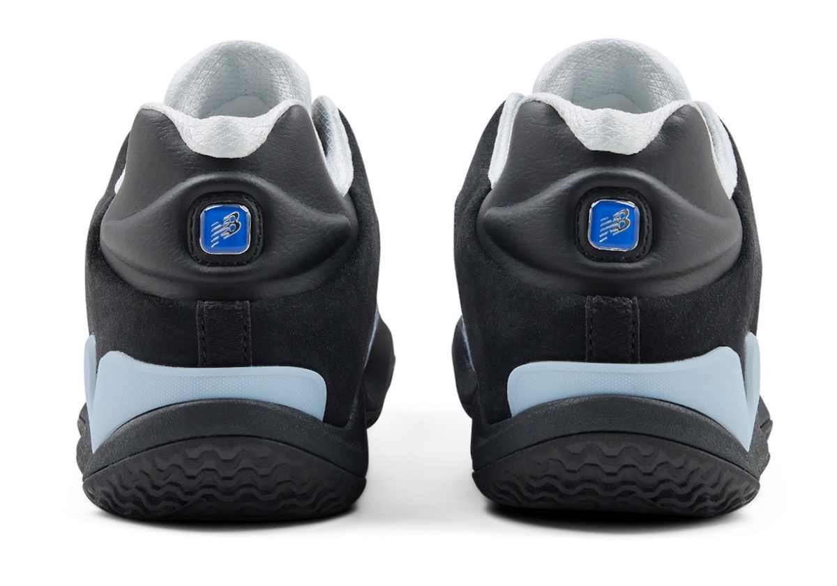 Talón de las New Balance Maxey V1 con la insignia Flying NB azul y los refuerzos celestes en la base
