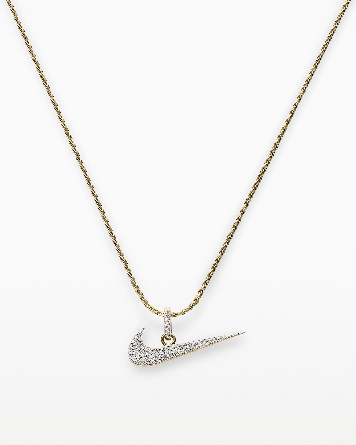 Collar Swoosh pavé de Nike sobre fondo blanco, con un Swoosh dorado cubierto de pequeñas piedras transparentes colgando de una cadena trenzada dorada