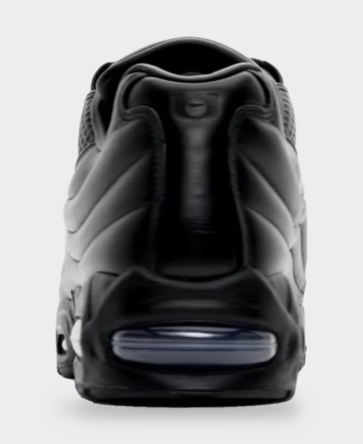 Talón de la Nike Air Max 95 Lux de One Block Down sobre fondo gris claro, todo en cuero negro, con la cámara Air azulada visible en la base