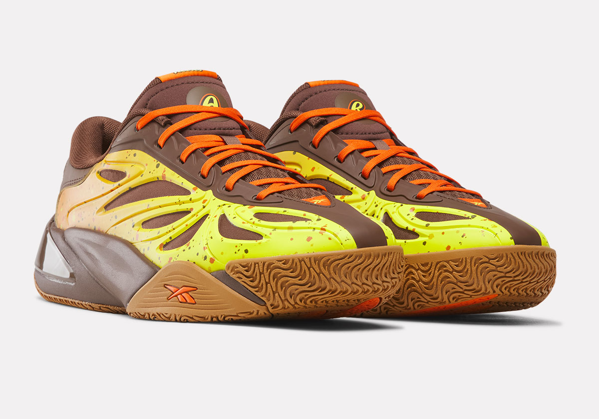 Par de Reebok Angel Reese 1 Reese's en marrón con upper amarillo y naranja moteado, cordones naranjas y suela de goma color caramelo