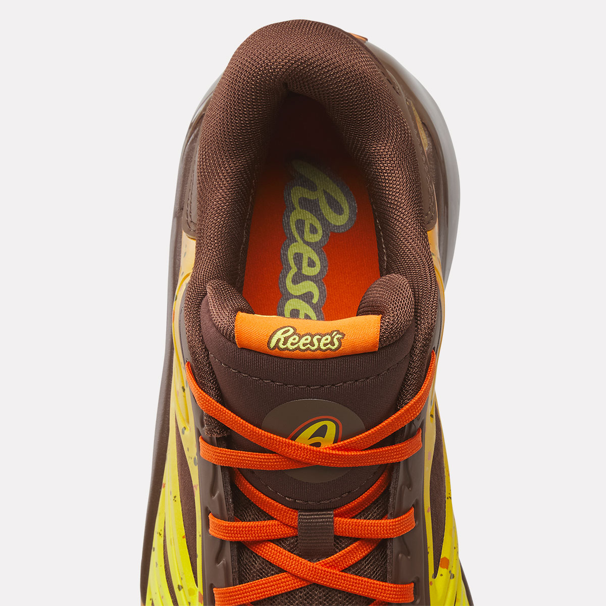 Detalle de la Reebok Angel Reese 1 Reese's con logo de Reese's en la lengüeta y en la plantilla naranja, y el monograma AR al frente