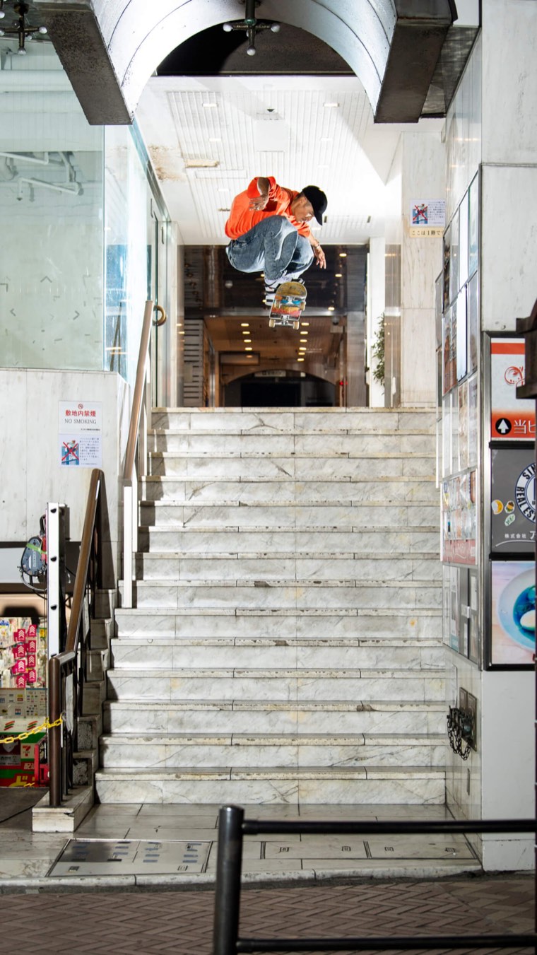 Ryuhei Kitazume salta con un nollie una escalera de mármol en la entrada de un edificio, de noche