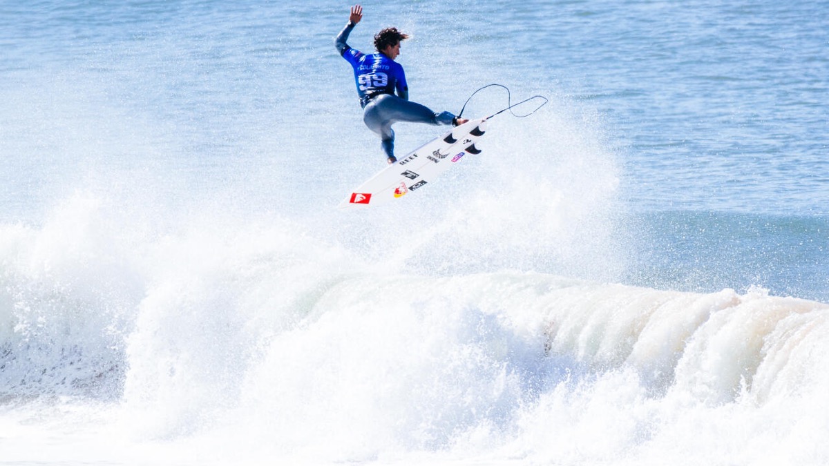 Foto de archivo: Griffin Colapinto, con la lycra azul, vuela sobre la espuma de una ola en Supertubos con la tabla en el aire, en la segunda ronda del MEO Rip Curl Pro Portugal