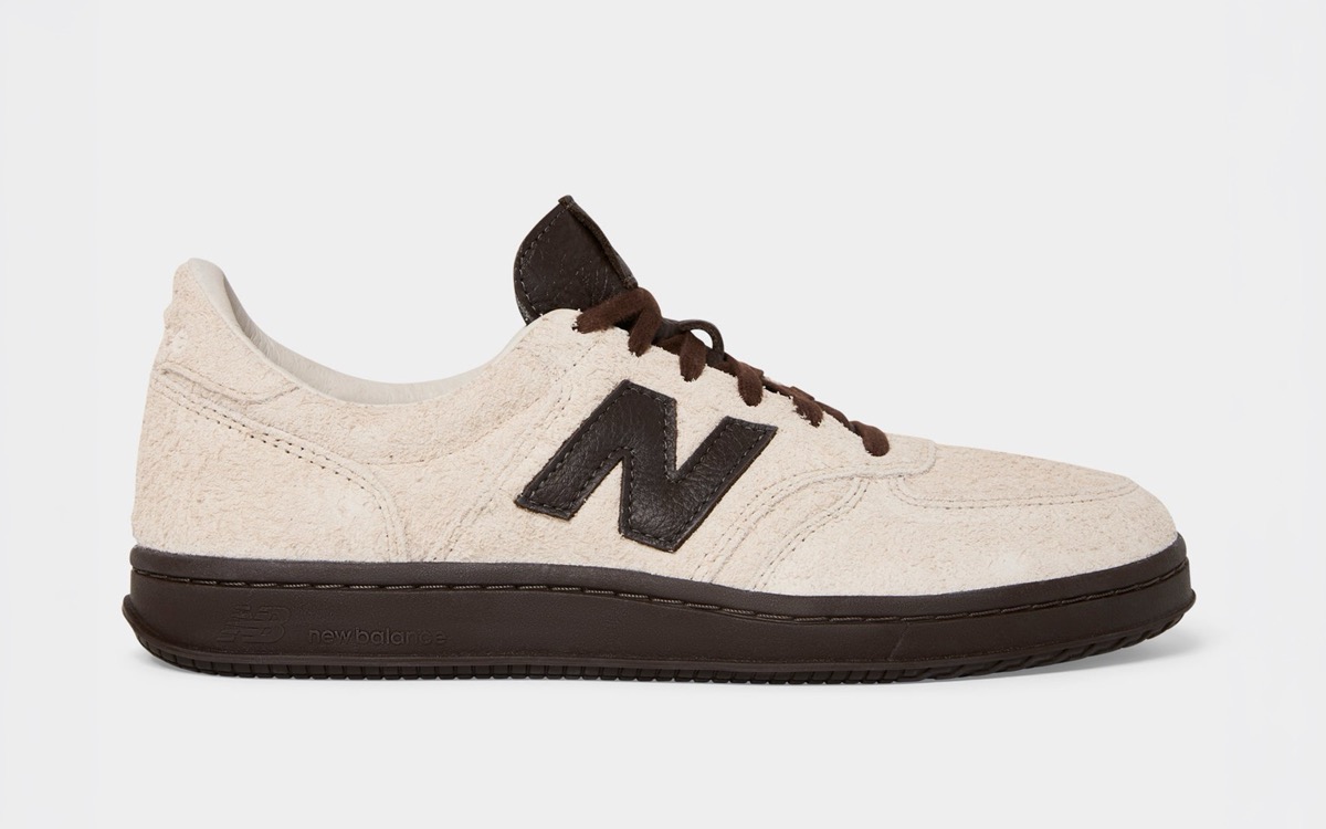 New Balance T500 Milk de Todd Snyder de perfil sobre fondo gris claro, en gamuza color crudo de pelo largo, con la N y los cordones en marrón oscuro y suela de goma marrón oscura