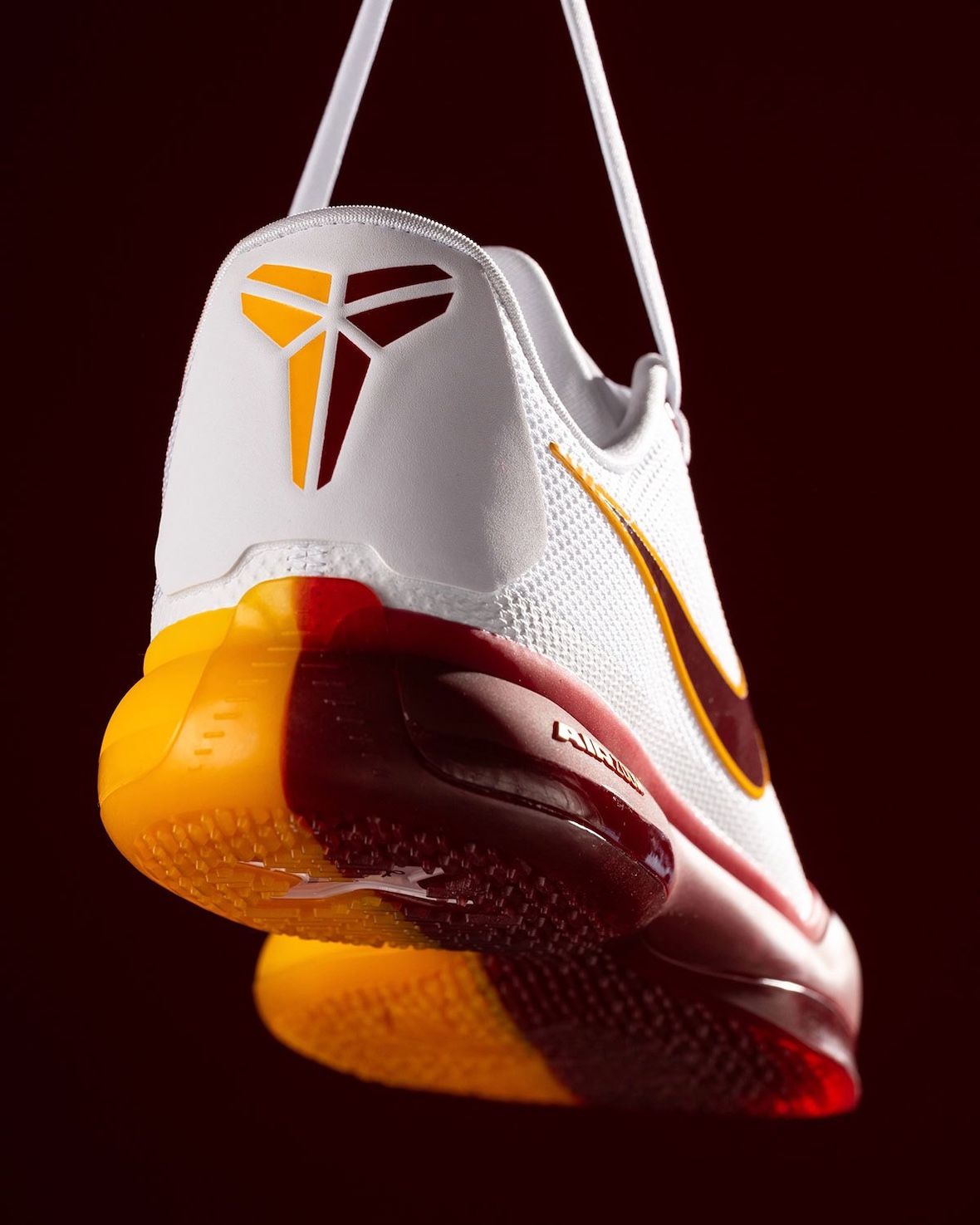 Talón de la Nike Kobe 10 Protro blanca de USC, con el logo de Kobe en dorado y la media suela amarilla y bordó