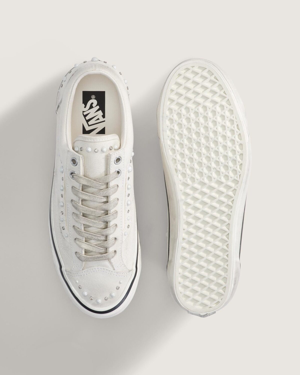 Vista superior del Vans Old Skool 36 Pearlized Marshmallow White junto a la suela waffle, con la plantilla de logo Vans y las perlas sobre la puntera de gamuza