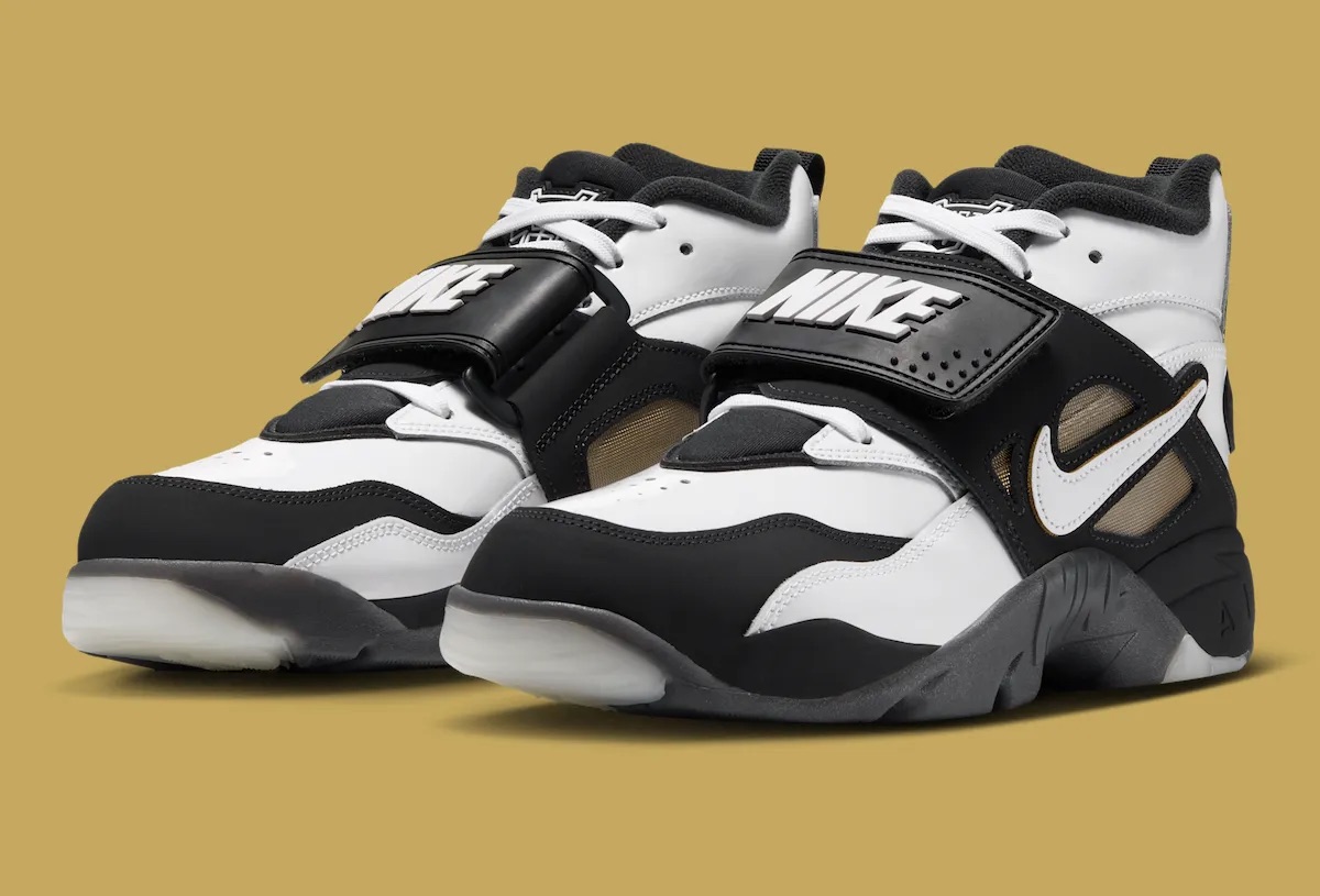Par de Nike Air DT Proto '92 de Well Off Forever sobre fondo dorado, con cuero blanco y negro, correa negra con el logo de Nike, Swoosh blanco y suela negra con base translúcida